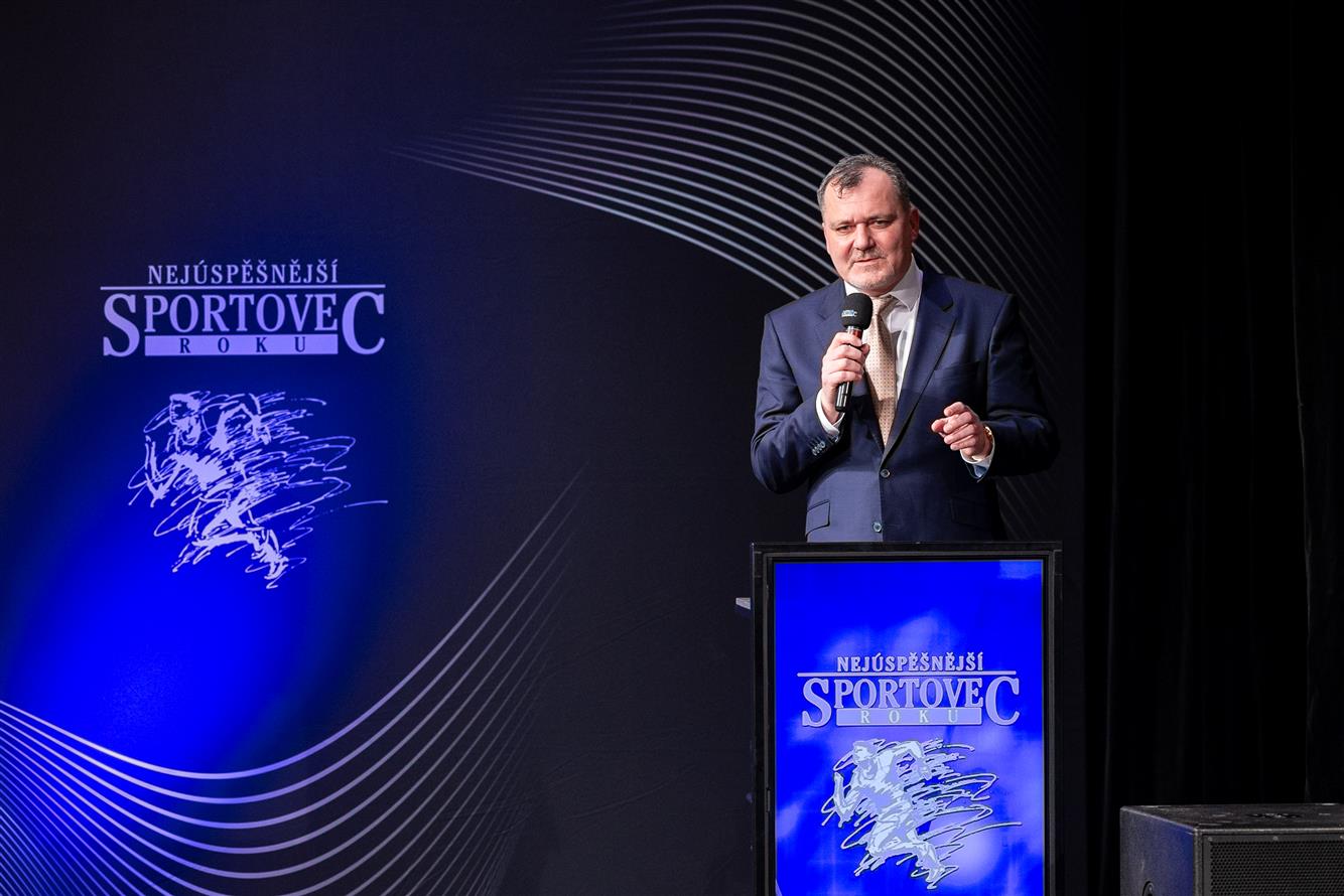 Sports award ceremony, mayor presenting award to athlete, elegant theater interior, celebration