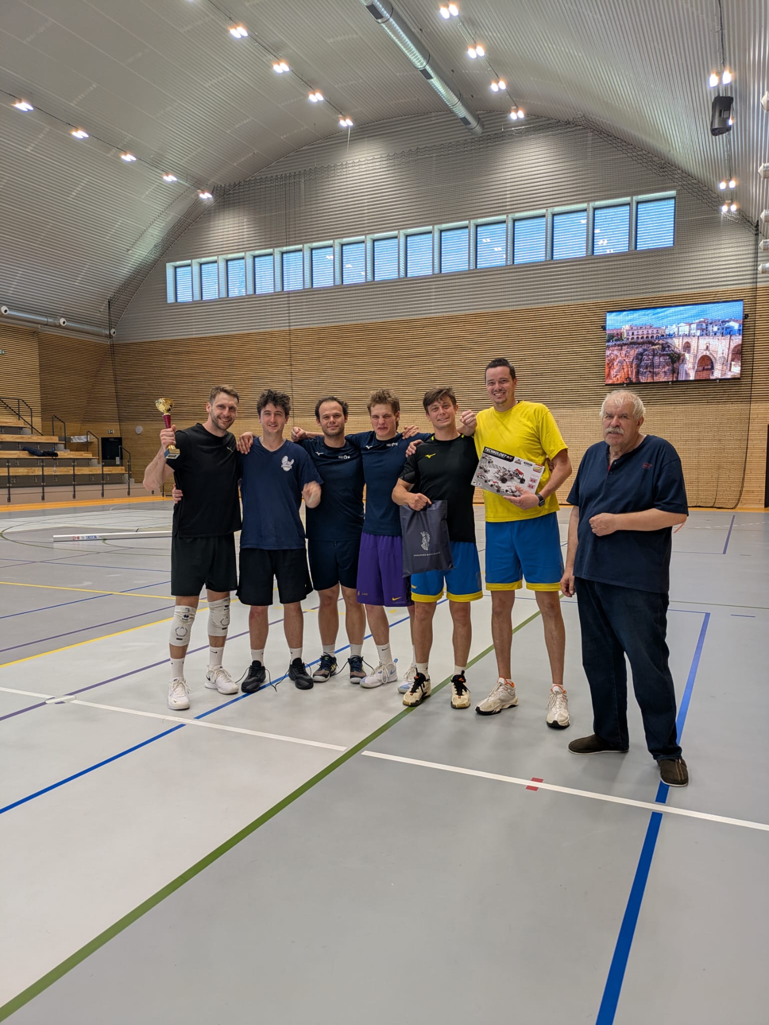Volleyball team trophy presentation, winning moment, sports hall interior